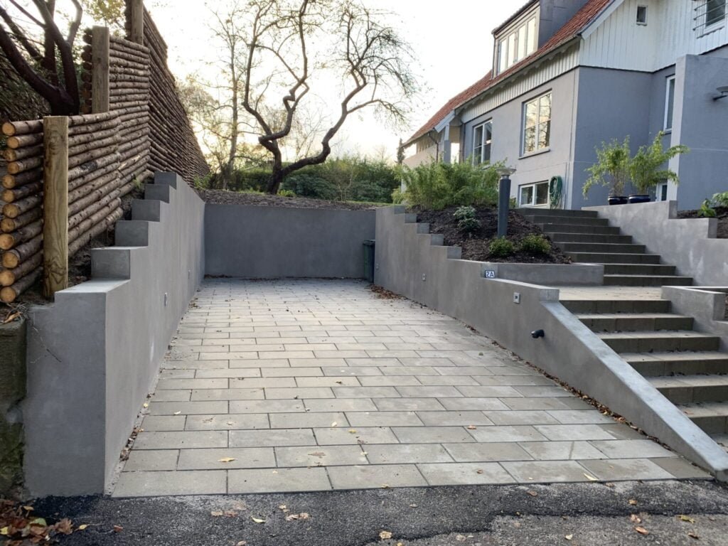 Nybygget indkørsel med trapper og grå mur