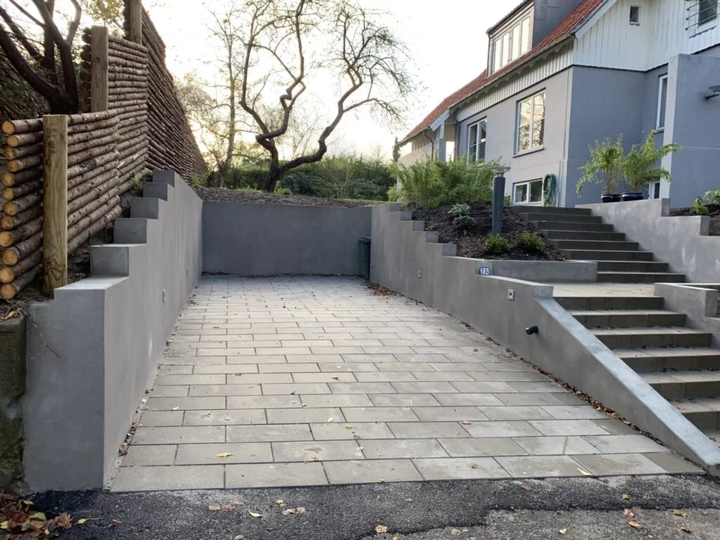 Nybygget indkørsel med trapper og grå mur