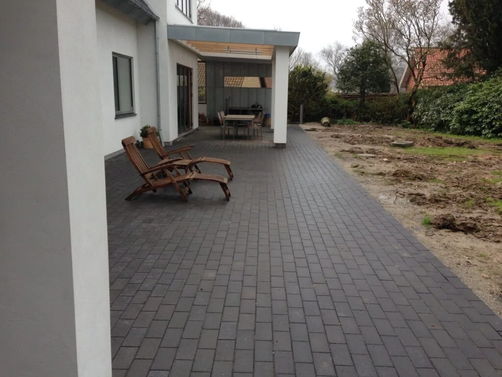 Moderne terrasse med sorte fliser og liggestole