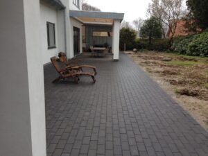 Moderne terrasse med sorte fliser og liggestole